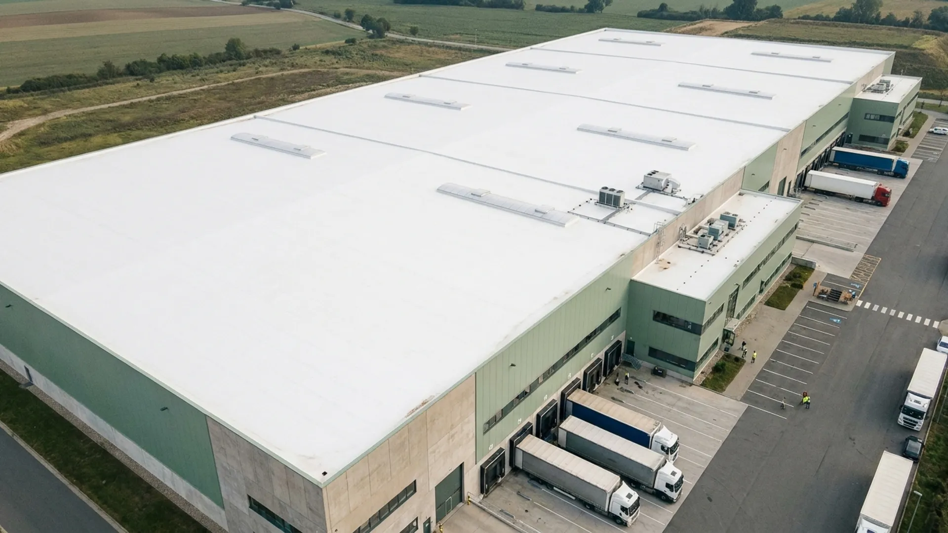 Groot wit gecoat dak van een logistiek bedrijfspand met laaddocks